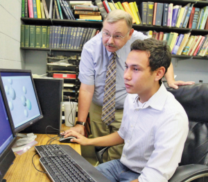 Carl Dirk, Ph.D., professor of chemistry,  left, and undergraduate researcher Jaime  Valencia are using high-performance  computing to study what happens to  fluorocarbons when they reach the upper  atmosphere. Photo by J.R. Hernandez  